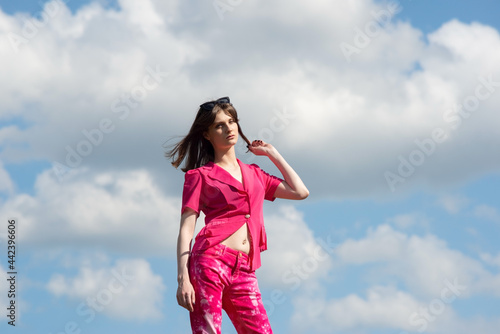 portrait of a fashionable girl in pink against the sky