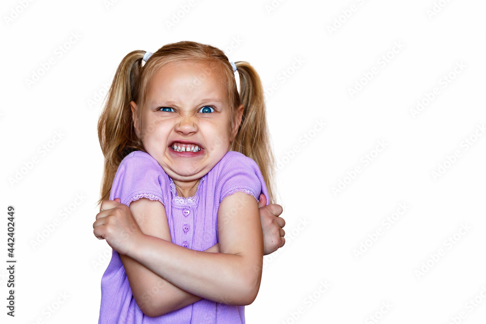 Baby on a white background. Little girl angry with folded arms Baby on a white background. Little girl angry with folded arms