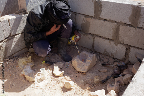Mauritanian artisanal gold miner smelting an aggregate made of gold captured by mercury. Mercury vapours are a safety hazard and can cause severe health issues by polluting the food Chain.
