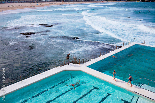Swimmers at Bondi Icebergs pool with Bondi Beach behind photo