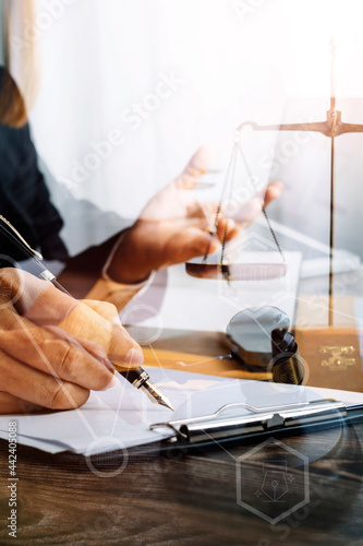 Business and lawyers discussing contract papers with brass scale on desk in office. Law, legal services, advice, justice and law concept picture with film grain effect