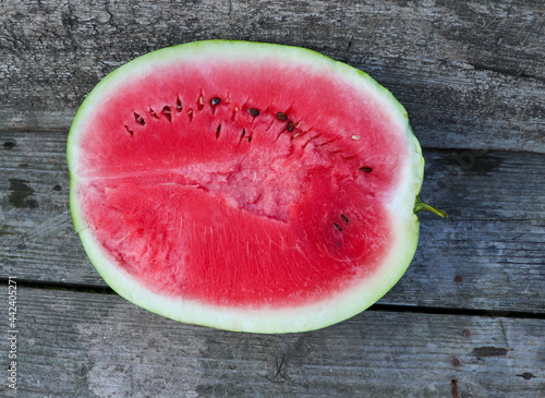 Cut in half watermelon on old wooden table background with top view