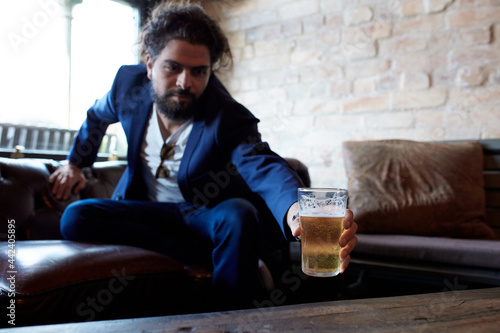 Hipster man enjoying drinking a beer at pub photo