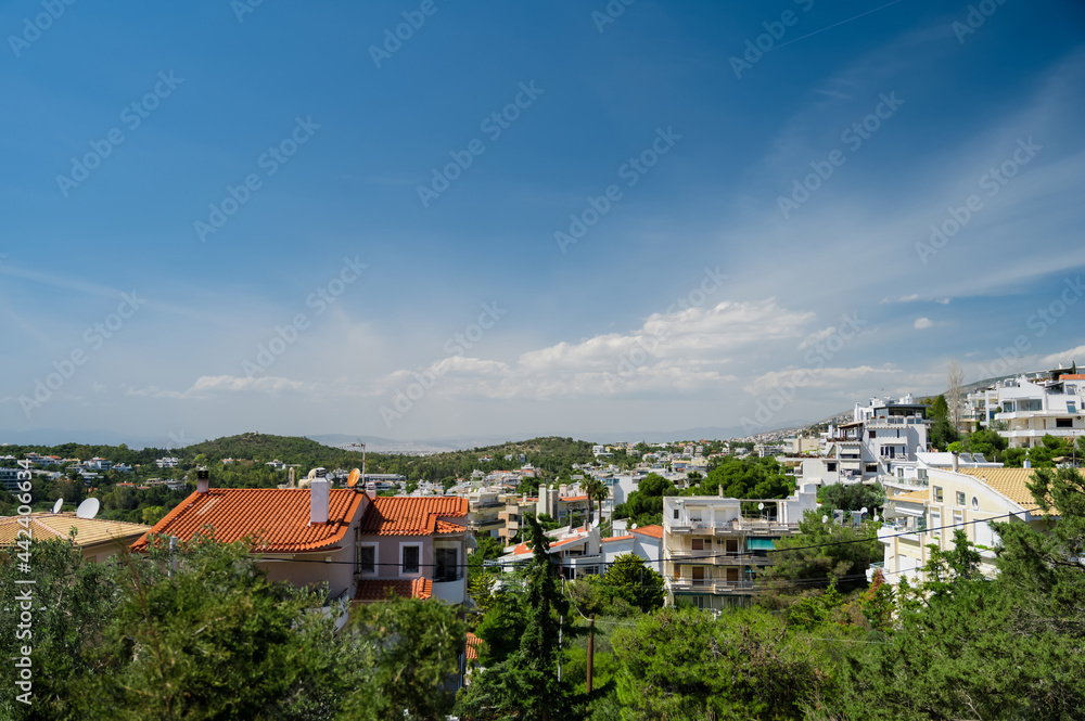 Naklejka premium Cityscape of Athens in Greece. Top view. Urban architecture and a lot of green trees. Hilly area. Sunne day.
