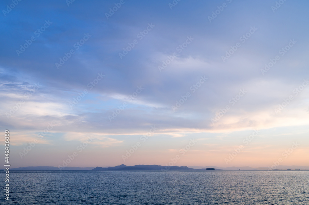 Beautiful landscape of sunset over Aegean sea in Athens, Greece. Calm water. Silhouettes of islands.