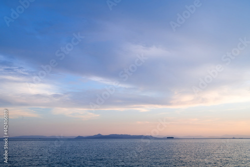 Beautiful landscape of sunset over Aegean sea in Athens, Greece. Calm water. Silhouettes of islands. © Anastasia
