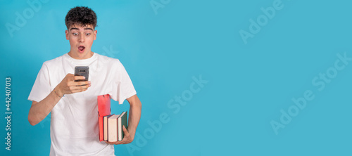 isolated student with books looking at mobile phone surprised