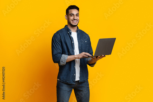 Handsome arab guy enjoying his new modern laptop