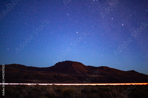 Car passing on the road and sky full of stars and milky way at night