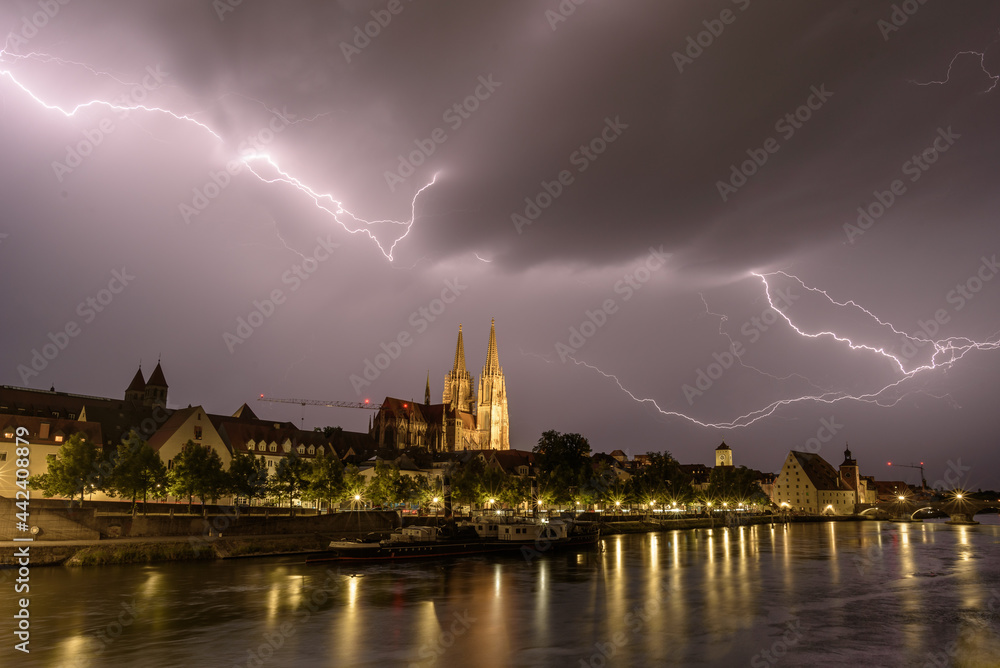 Gewitter über Regensburg am Abend mit Blitzen und Dome beleuchtet