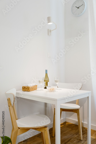 A white table with wine  perfect for a couple in a bright minimalist room.