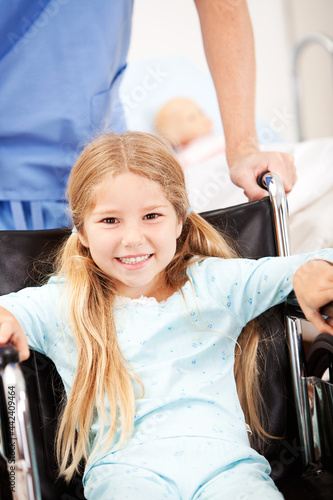 Hospital  Nurse Pushes Girl with Pigtails in Wheelchair