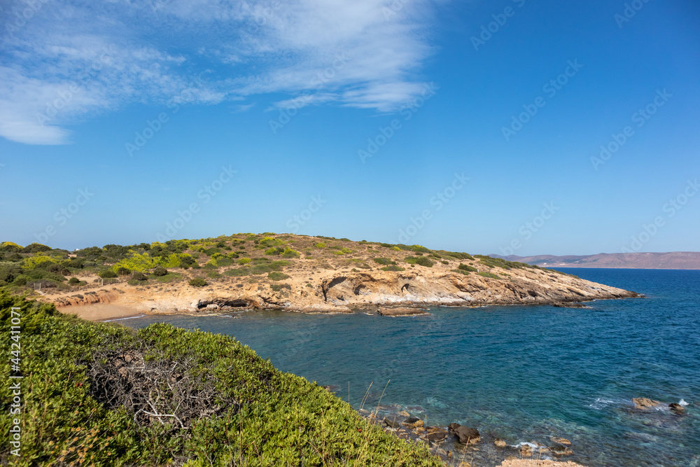 Rocky, with green bushes, wild cliffs, sea shore line landscape near Athens, Greece. Vibrant colorful summer view with blue clear Mediterranean sea