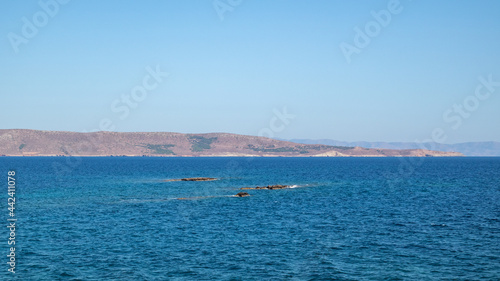 Wild mediterranean seascape with rocks in blue clear water. Travel Greece near Athens. Summer nature scenic sea view with blue sky