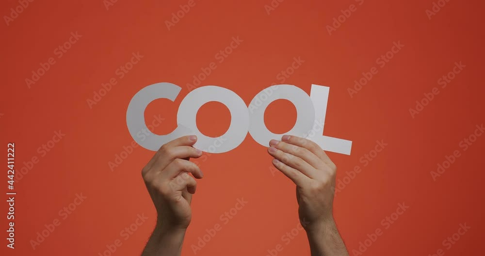 Hands showing word cool of english language. Man shows word made of carved paper for blog screen saver, comics Hands showing word cool of english language. Man shows word made of carved paper for blog screen saver, comics