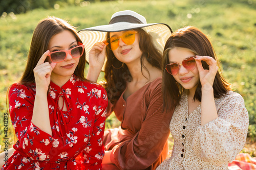 three beautiful young women in sunglasses in summer in the park 