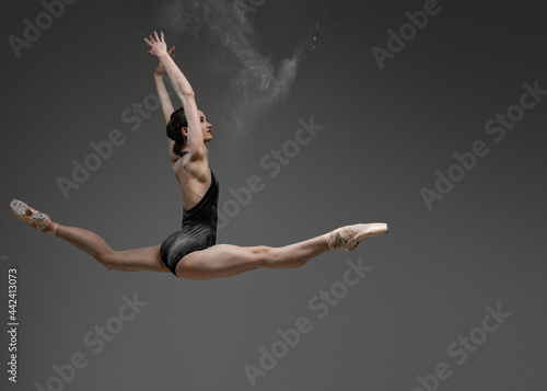 Wallpaper Mural Leaping woman with raised arms against gray background Torontodigital.ca