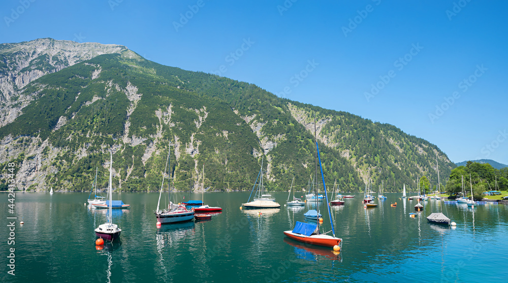 colorful moored sailboats, lake Achensee, mountain view Seebergspitze, austria