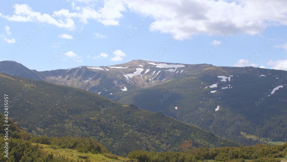Fototapeta premium View of the mountain of the Montenegrin ridge. There is snow on the mountain, the growth of a tree. Place of the hiking trail.