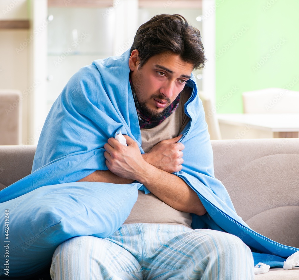 Fototapeta premium Sick young man suffering from flu at home