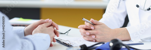 Doctor communicating with patient in clinic closeup