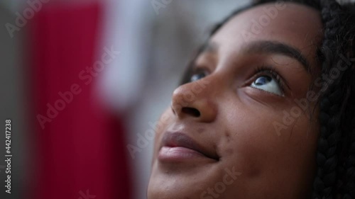 Pensive Black girl child close-up face looking up at sky photo