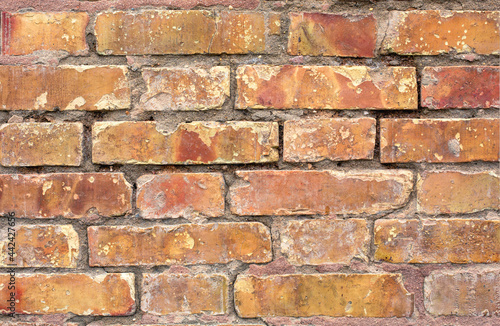 Old shabby brick wall surface of a red hue.