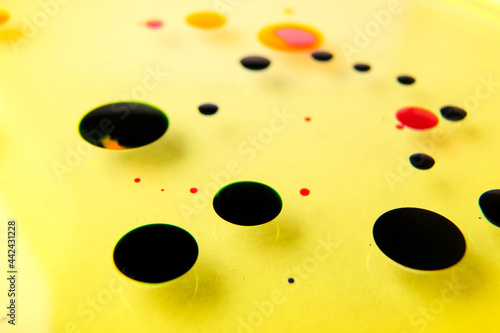 closeup ptoto of color ink float on yellow oiil photo