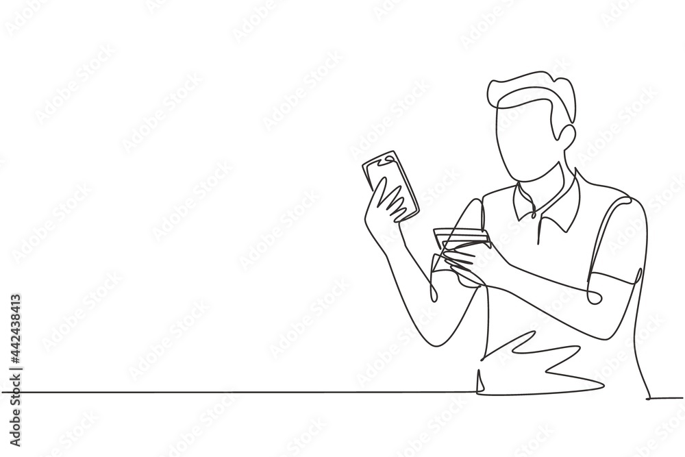 Single one line drawing young man sitting on chair and typing entering credit card code on laptop around desk. Digital payment concept. Modern continuous line draw design graphic vector illustration
