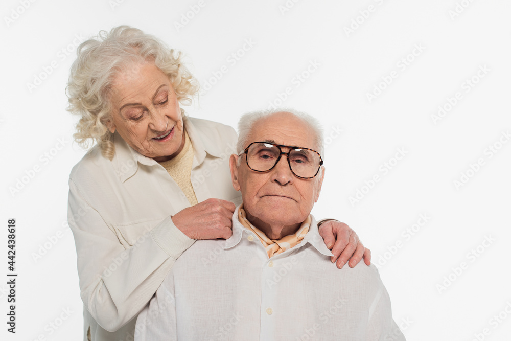 elderly woman gently hugging and looking at husband isolated on white elderly woman gently hugging and looking at husband isolated on white
