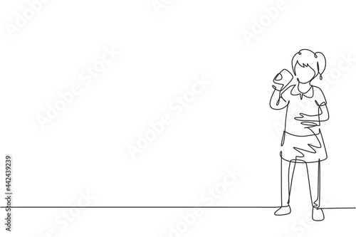 Single continuous line drawing girl standing while drinking a glass of milk to fulfill body's nutrition. Healthy lifestyles concept for kids. Dynamic one line draw graphic design vector illustration