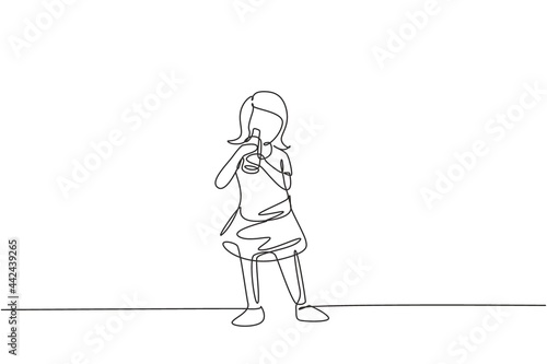 Continuous one line drawing girl standing while drinking milk in a bottle to fulfill her body's nutrition. Healthy lifestyles concept for kids. Single line draw design vector graphic illustration