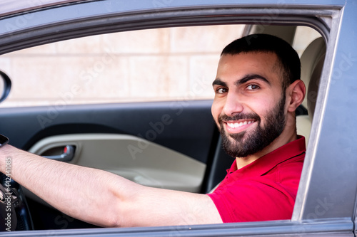 Arabic man driving his car with smile and feeling confident