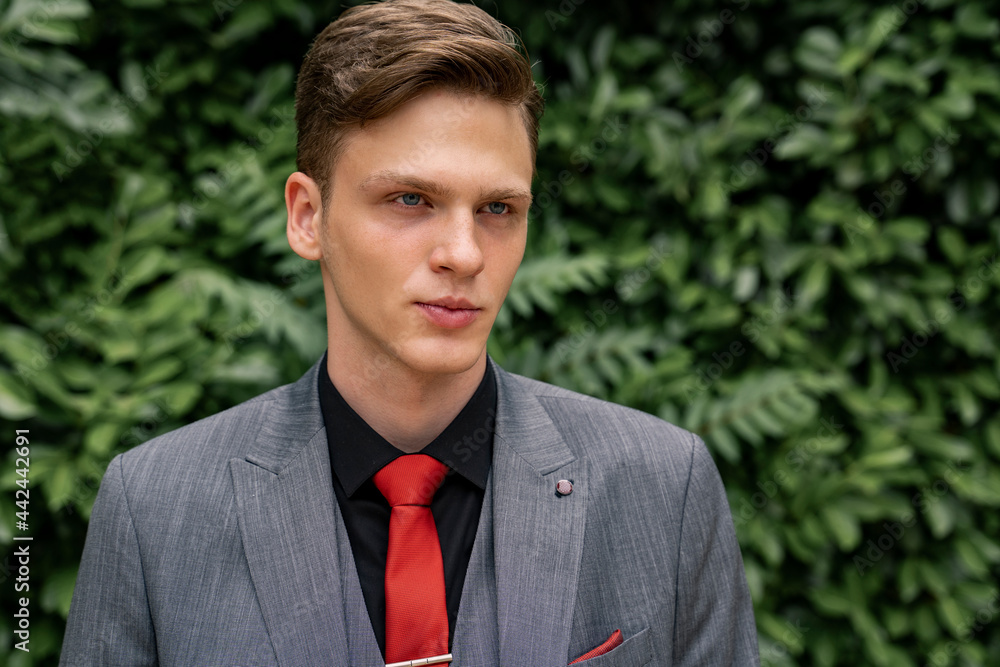 Handsome teenager in suit and tie , posing, serious face Handsome teenager in suit and tie , posing, serious face