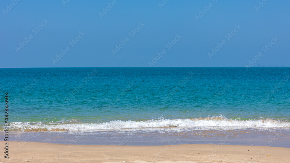 Selective focus sea wave bubbles on a peaceful beach in tropical. Crystal clear white water bubbles at sandy beach