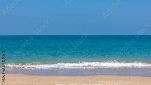 Selective focus sea wave bubbles on a peaceful beach in tropical. Crystal clear white water bubbles at sandy beach