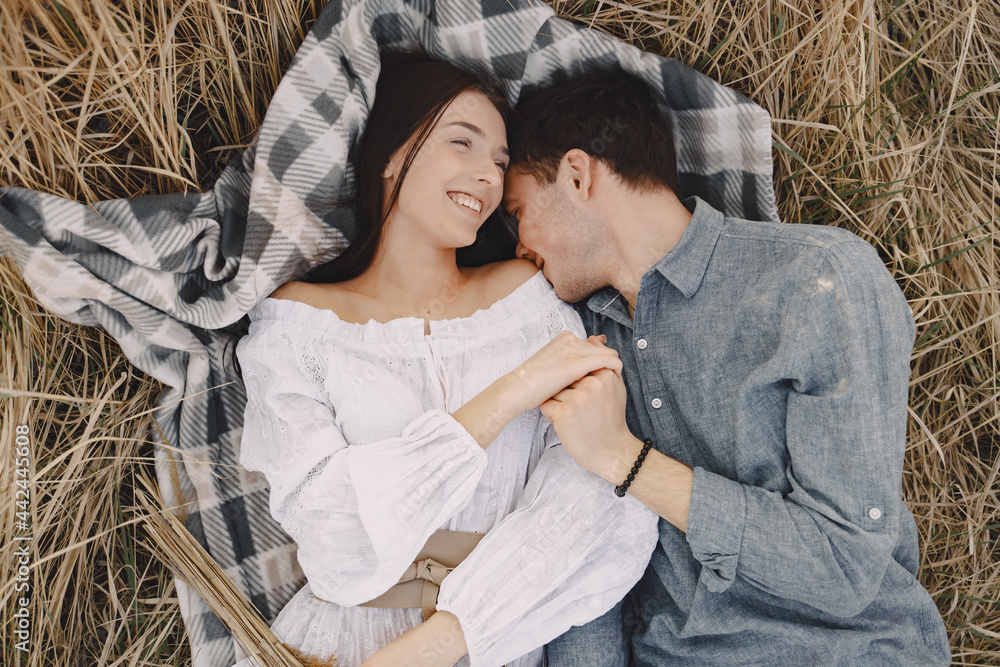 Obraz premium Happy couple in love in wheat field at sunset