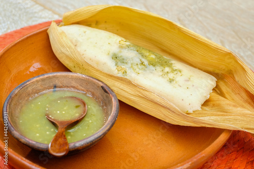 Photos tamale stuffed with chicken and green sauce with spicy chili peppers