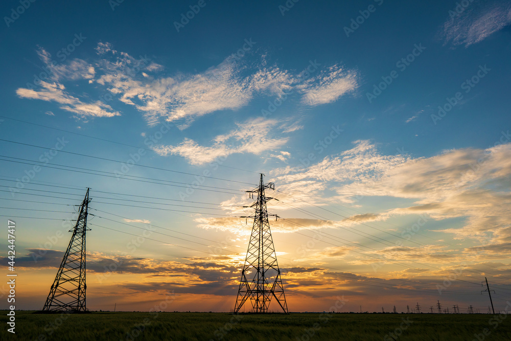 power line pylons during sunset with beautiful saturated sky. distribution transmission and consumption of electricity power line pylons during sunset with beautiful saturated sky. distribution transmission and consumption of electricity