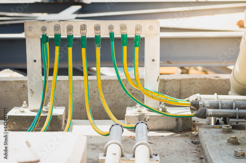 Electrical high voltage ground bar on wall.Grounding electric bar.Cables connected to electrical grounding bar,Ground industry for control system.