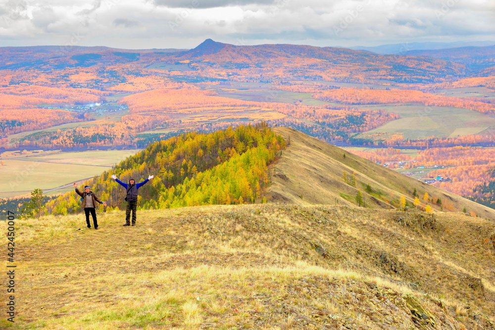 mature male tourists walk along the ridge of the big krak on an autumn day. - obrazy, fototapety, plakaty 