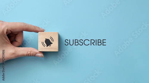 Foto A wooden cube with drawings of a bell and the inscription: subscription