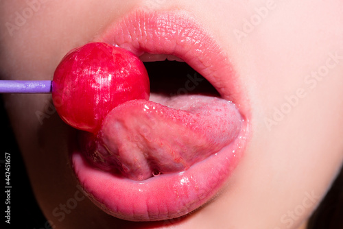 Licking tongue lips. Lips with candy, sexy sweet dreams. Oral sex blow job concept. Female mouth licks chupa chups, sucks lollipop.