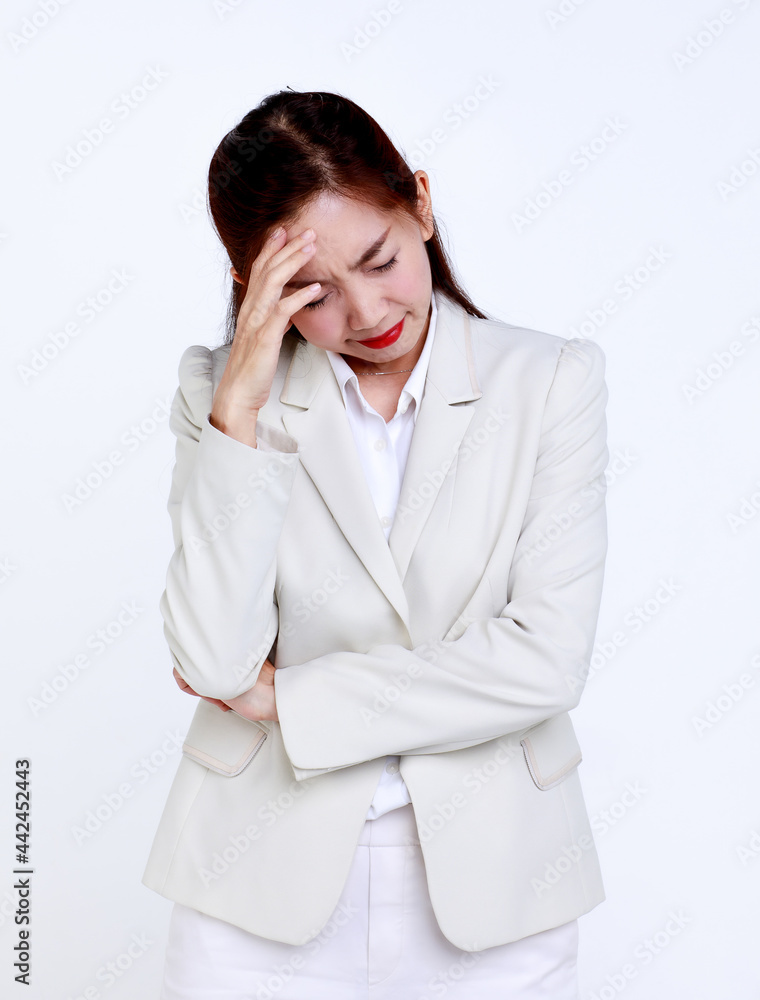 Young Asian businesswoman in formal suit touching forehead while suffering from headache because of business problem against white background