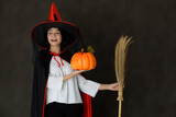Happy witch with pumpkin and broom