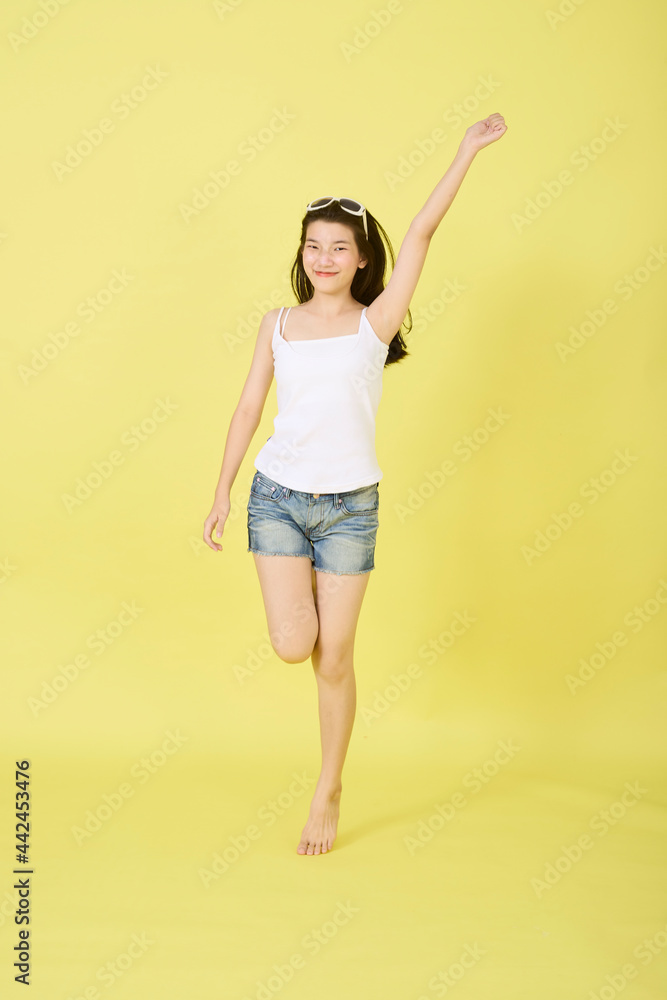 Happy woman jumping on yellow summer backgrounds