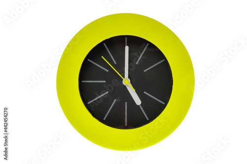 Round modern clock with white stripe, yellow clock hands pointing at the center possess time, five pm or am. Middle of the clock is black surrounded by green circle flame. Isolated on white