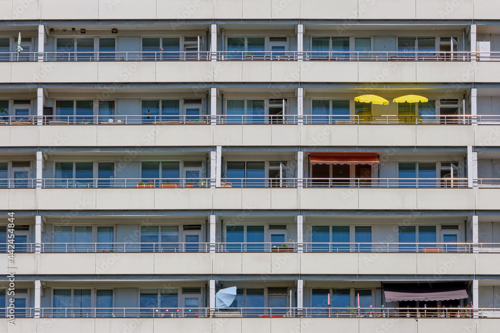 Facade of a big apartment building with yellow sunshades on one of the balconies Facade of a big apartment building with yellow sunshades on one of the balconies