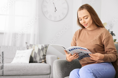 Beautiful woman reading mag...