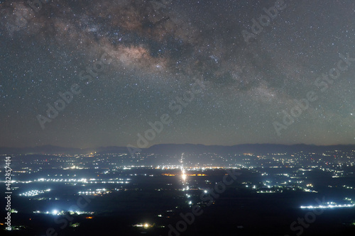 The Milky way in night sky over the town in Lopburi province Thailand.